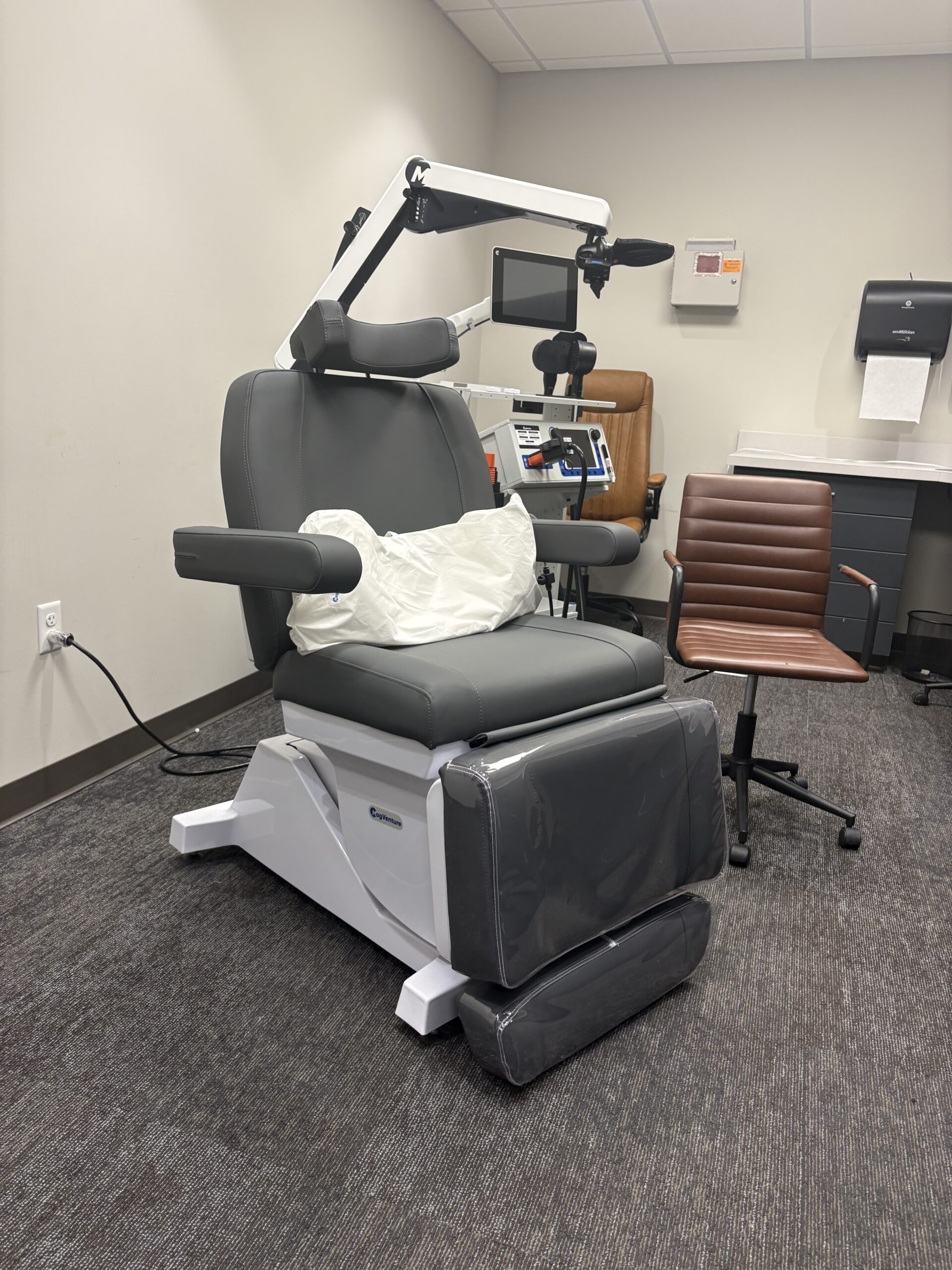 A TMS therapy treatment chair and magnetic coil in a treatment room at the Dallas–Fort Worth clinic